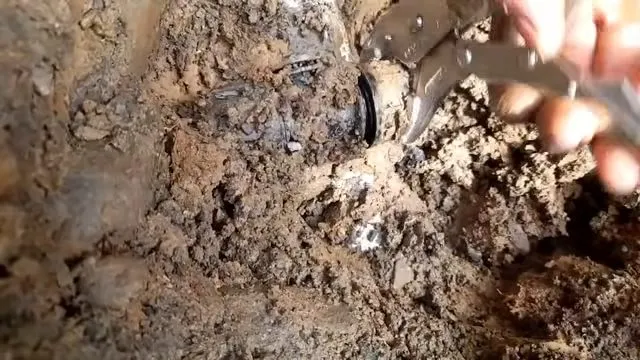 Exposed broken water line under muddy water