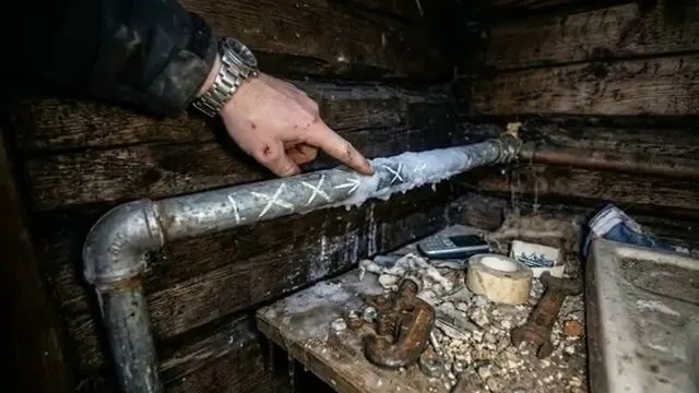 Inspecting a frost-damaged metal pipe