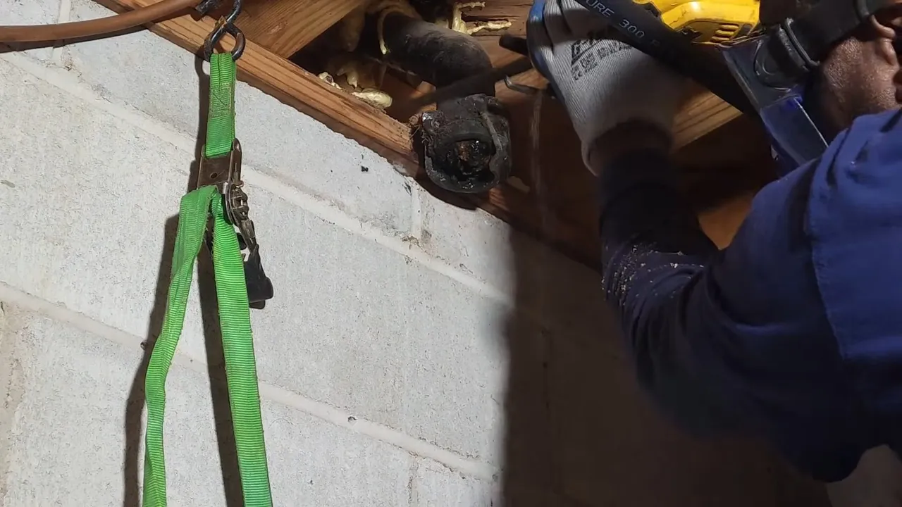 Plumber cutting an exposed cast-iron pipe