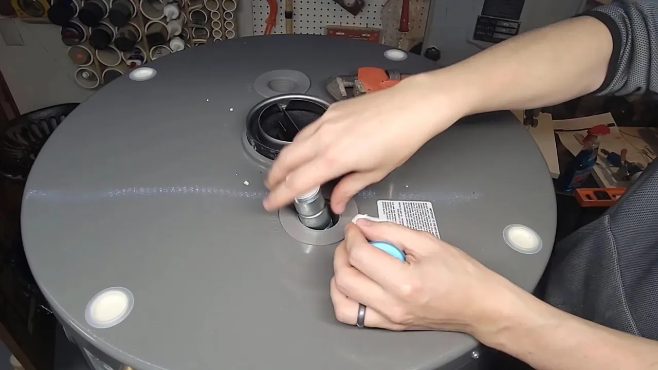 Plumber tightening a water heater top fitting
