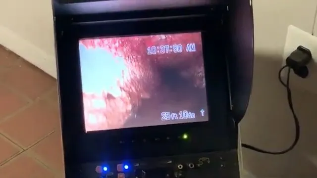Pointing out a blockage on a sewer camera monitor