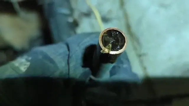 A finger pointing to a freeze-damaged section of copper pipe