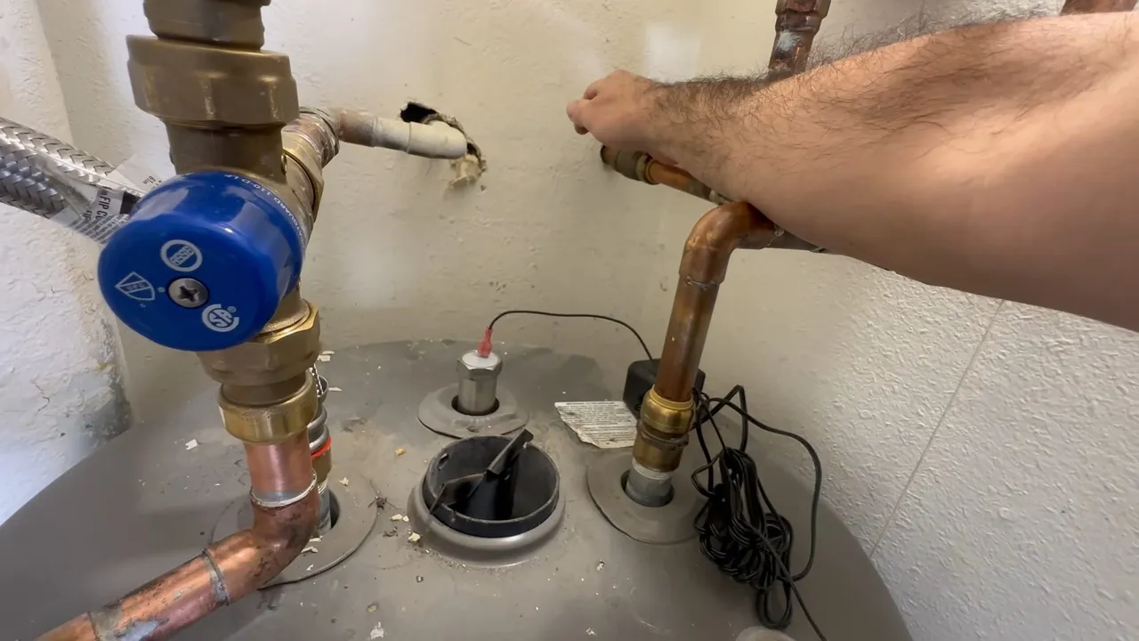 Technician inspecting a water heater anode rod
