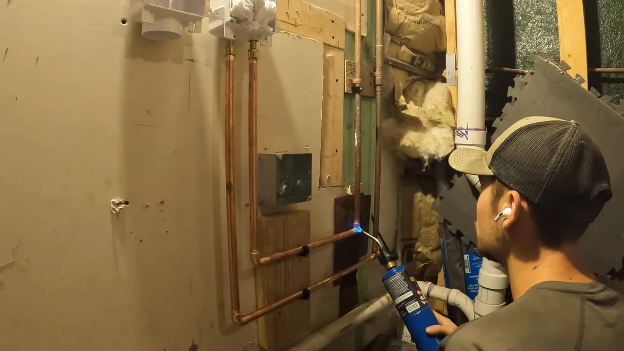 Washer and dryer plumbing in an open basement wall